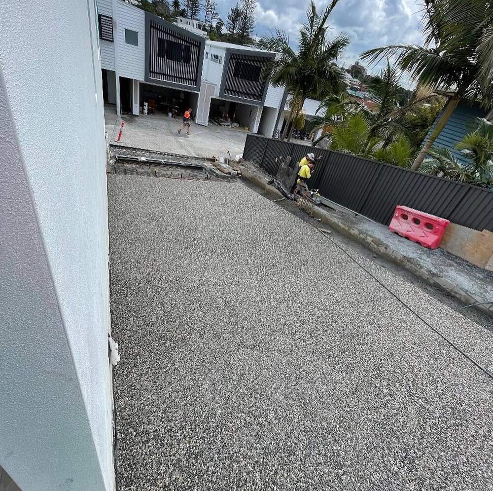 Exposed aggregate concrete driveway crew finishing