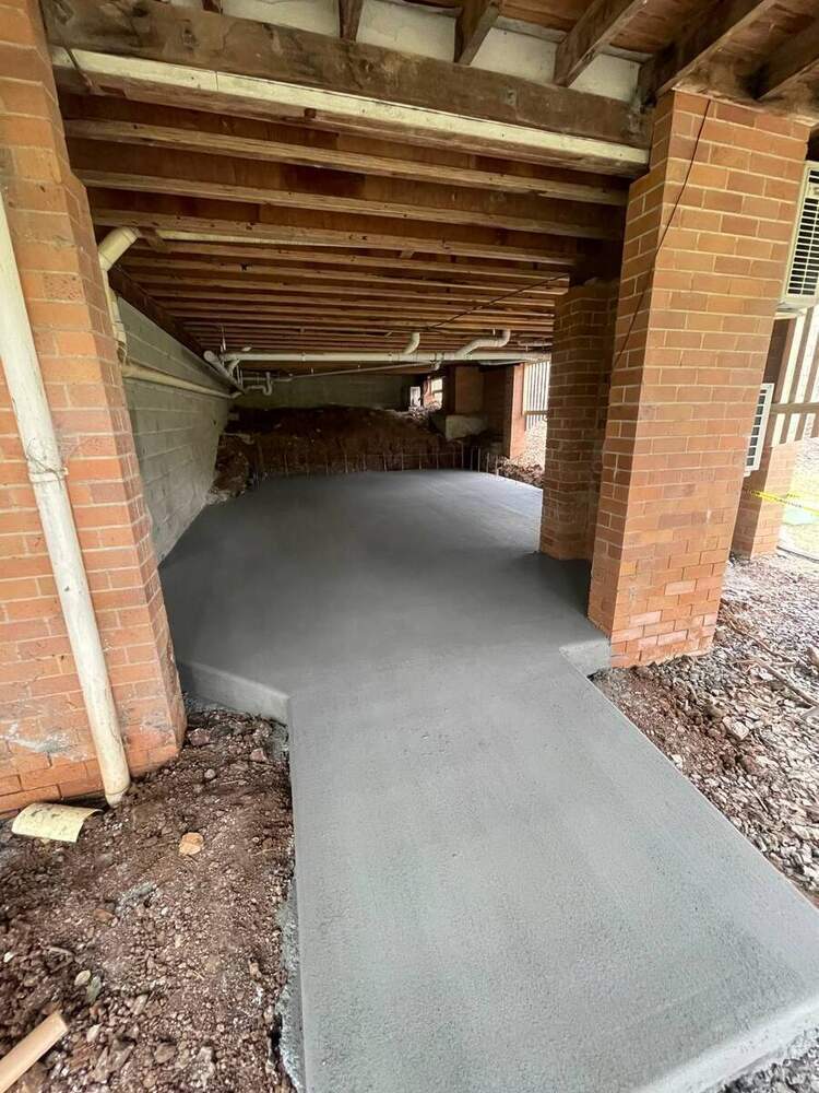 Fresh concrete slab poured under building with brick columns